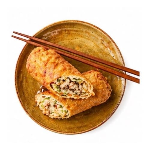 Crispy egg roll cut in half on a plate