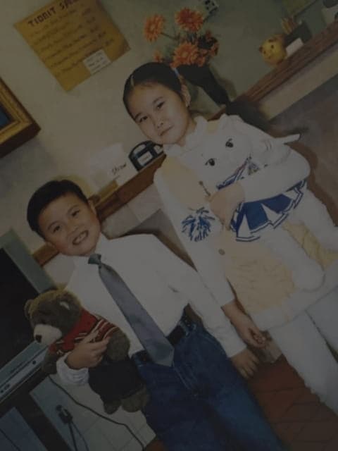 The owners' children as kids, dressed up and holding stuffed animals
